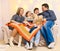 Portrait of a family sitting on a sofa at home, four people having fun together