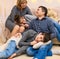 Portrait of a family sitting on a sofa at home, four people having fun together