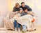 Portrait of a family sitting on a sofa at home, four people having fun together