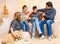 Portrait of a family sitting on a sofa at home, four people having fun together