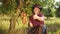 Portrait of farmer in hat showing thumbs to up in the apple garden