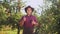 Portrait of farmer in hat showing thumbs to up in the apple garden