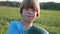 Portrait of farmer`s son with whole watermelon at field of farm.