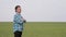 Portrait of farmer standing in a wheat field. senior farmer with folded hands dressed in blue shirt with squares