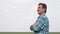 Portrait of farmer standing in a wheat field. senior farmer with folded hands dressed in blue shirt with squares