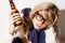 Portrait, fashion and a bottle of beer with a woman in studio isolated on a white background feeling dizzy closeup. Face