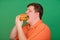 Portrait of a fat guy with a big hamburger in his hands, isolated on a green background. Chroma key, green screen