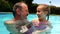 Portrait of father and daughter in swimming pool