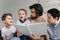 portrait of father and little sons reading book together