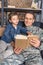 portrait of father in military uniform and son reading book together