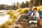 Portrait Of Father And Son Fishing By Lake