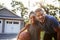 Portrait Of Father And Son Playing Basketball On Driveway