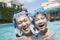 Portrait of father and son with snorkeling equipment in the pool