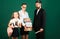 Portrait of father tutor and school kids daughters on green blackboard background. Reading book and writing. Dad