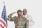 Portrait of father with US Marine Corps soldier saluting American flag over gray background