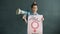 Portrait of female activist standing on grey background with feminism banner and megaphone