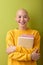 Portrait of female with bald head holding books in hands and smiling, enjoying education