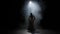 Portrait of female on black background under spotlight projector in studio. Ballerina in white tulle showing flexible