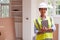 Portrait Of Female Building Surveyor Wearing Hard Hat With Digital Tablet Looking At New Property