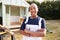 Portrait Of Female Carpenter Building Outdoor Summerhouse In Garden