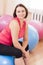 Portrait of Female Caucasian Athlete In Good Fit Sitting on Big Fitballs