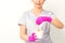 Portrait of a female caucasian beautician holding a jar of sugar paste for sugaring wearing pink gloves on white