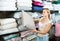 Portrait of female customer choosing pillow in bedding section