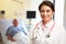 Portrait Of Female Doctor With Patient In Background