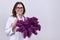 Portrait of female doctor with stethoscope with bouquet of lilac flowers