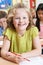 Portrait Of Female Elementary School Pupil Working At Desk