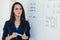 Portrait of female english teacher in front of whiteboard.