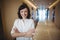 Portrait of female executive standing with arms crossed in corridor