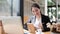 Portrait of female executive thinking over working schedule for employee writing report into notebook while using laptop computer.