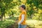 Portrait of female farm worker wearing orange t-shirt and trucker`s hat in walnut tree orchard