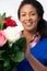 Portrait Of Female Florist Arranging Bouquet Of Lillies And Roses Against White Background