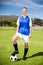 Portrait of female football player standing with her feet on ball