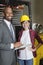 Portrait of female industrial worker standing with male inspector