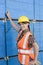 Portrait of female industrial worker standing by stacked wooden planks