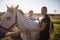 Portrait of female jockey and vet standing by horse