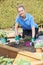 Portrait Of Female Landscape Gardener Planting Flower Bed In Gar