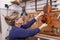 Portrait of female mature violin maker while testing the violins