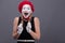 Portrait of female mime with red hat and white