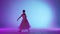 Portrait of female on purple background in pink neon light studio. Gentle ballerina in white tulle dancing jumping