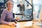 Portrait of female radio host using computer in studio