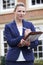 Portrait Of Female Realtor Standing Outside Residential Property