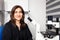 Portrait of a female scientist in the laboratory next to an inverted microscope