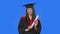 Portrait of female student in cap and gown graduation costume, holding diploma and showing ok gesture. Young woman