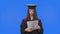 Portrait of female student in graduation costume, looking through documents, tearing them up and throwing away. Young