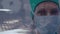 Portrait of female surgeon wearing face mask against time-lapse of people walking