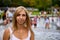 Portrait of a female tourist with people in the background, playing in the water in the Diana Memorial Fountain, Hyde Park, London